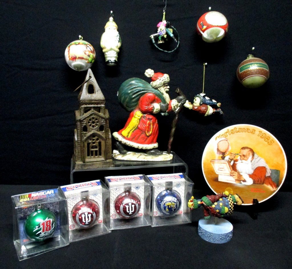 Christmas Ornaments Plus Lot: Including cast iron 9 Santa door stop, 10 ornaments: glass Santa, Univ. of Indiana & Kentucky, Nascar #18, Boyd's collectible Barnaby Homeward Bound, handmade Snow Light on stand, 1985 Rockwell plate,
