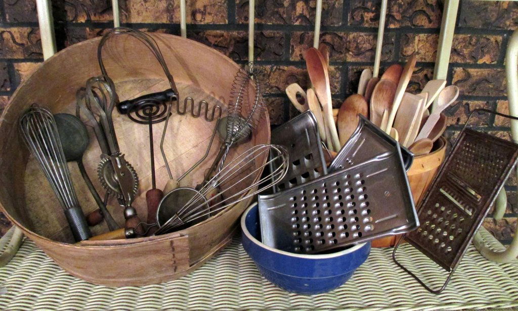 Vintage Kitchen Utensils Plus: Over 20 wooden spoons, metal whisks, mashers, beater, strainer, ladle, scooper (most w/wood handles), graters, 7" mixing bowl, 14.5" D cheese box, 9" bushel basket.