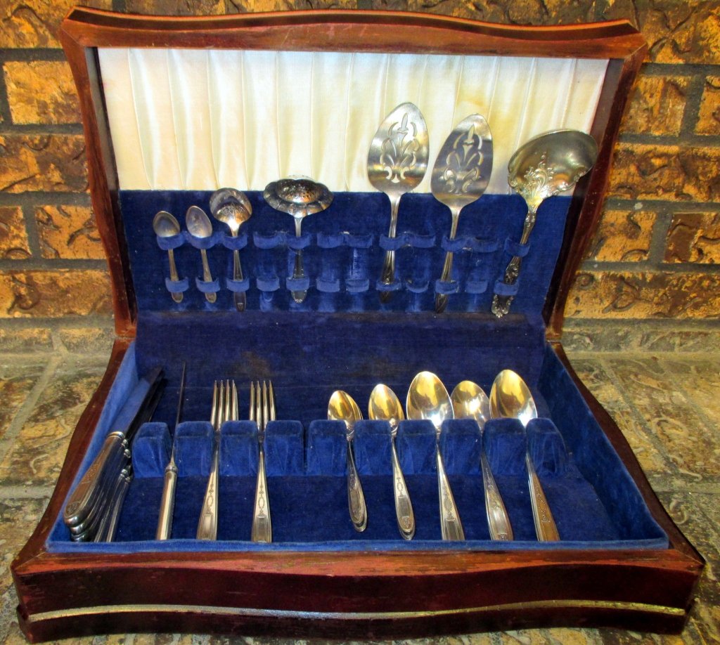 Community Grosvenor Silverplate Flatware: 24 pieces, patented 1921 together with a variety of odd serving spoons and a stainless tea strainer.