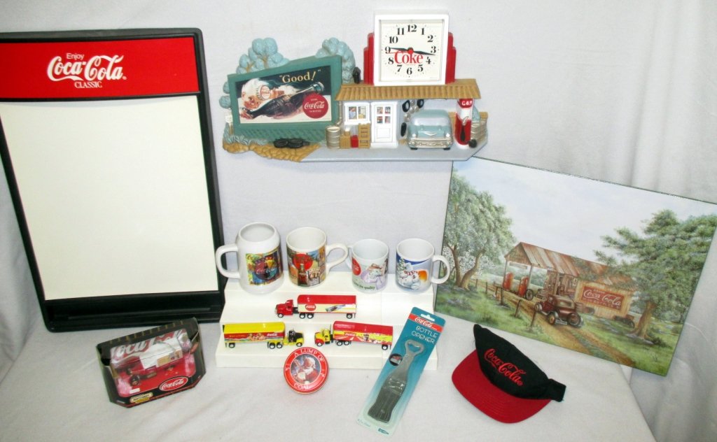 Coca-Cola Collectibles: Eraser board, clock, Matchbox 1932 Ford Model AA truck priced $19.98, 3 Matchbox semi trucks, bottle opener in orig. package, cap, shrink wrap poster and 4 mugs.