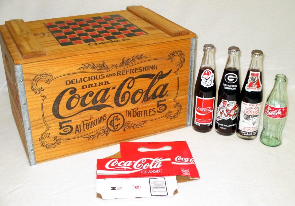 Wooden Coca Cola Checkers Crate & Shack Diorama: W/Jaguars carrier & 3 Cokes: Crimson Tide & Bear Bryant, 1980 GA Bulldogs and University of GA Bicentennial; together w/empty Classic Coke bottle. Together w/diorama having Coke decorations.