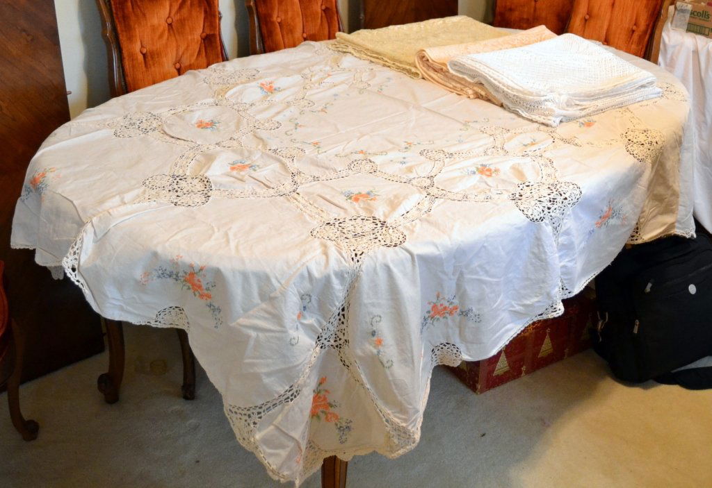 Crocheted & Lace Tablecloth Lot: Crocheted & cross-stitch cloth (60" x 80"), shiny lace cloth (62" x 84"), machine lace cloth (72" x 92") and a white Christmas lace cloth (56" x 64").