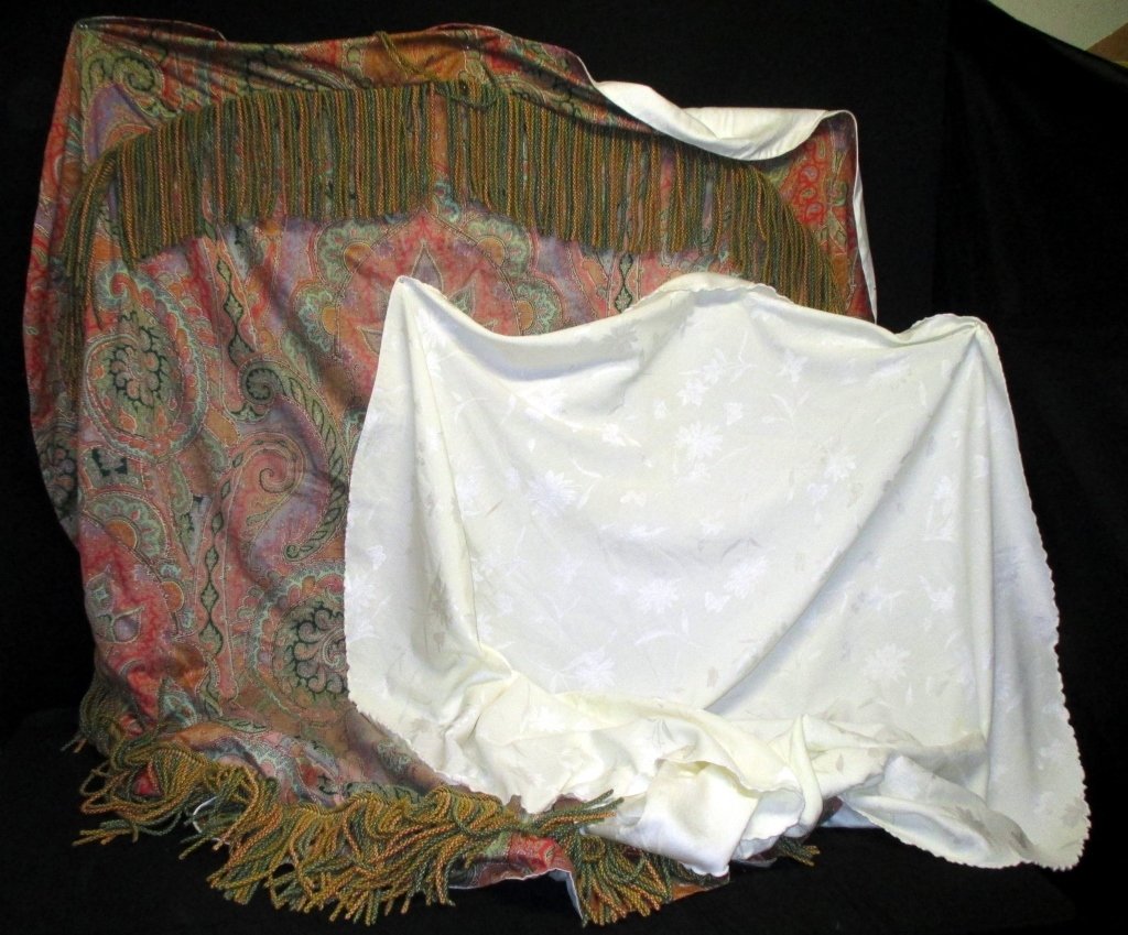 Two Round Tablecloths: 65" diameter white on white cloth, 71.5" diameter multi-color paisley w/heavy fringe.