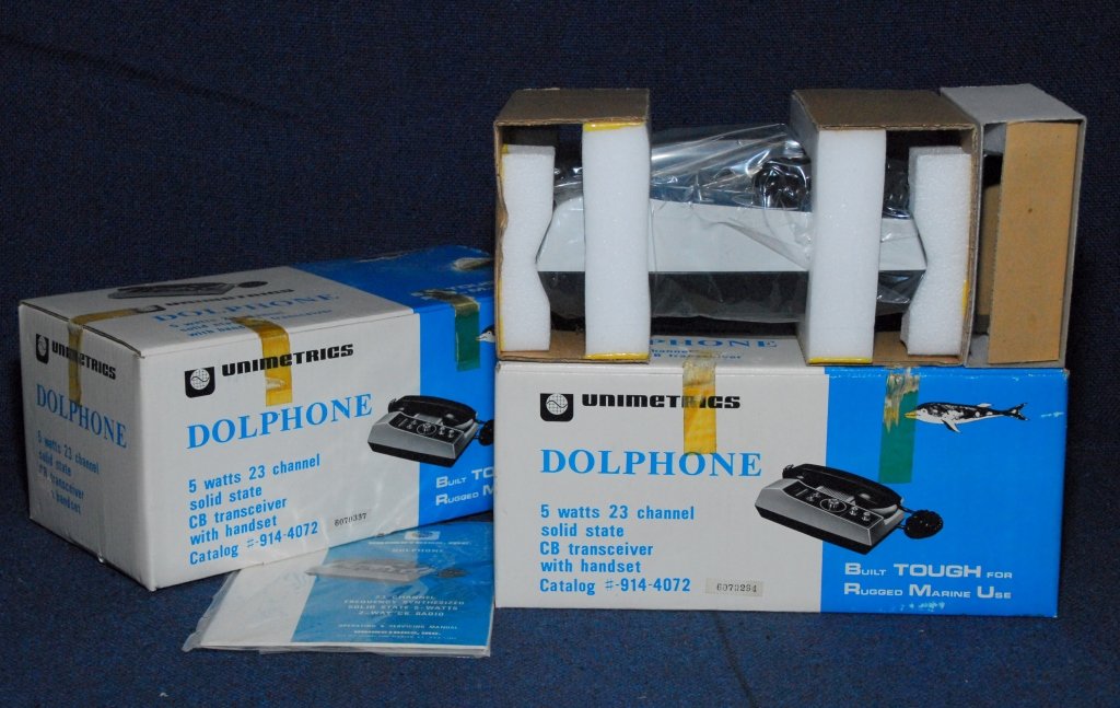 Two Unimetrics, Inc. Dolphone: 5 watts, 23 channel, solid state, CB transceiver w/handset. Both appear mint in the box.