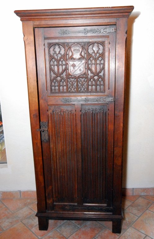 Narrow Gothic One Door Oak Armoire: Shield on upper door w/gothic tracery, linen fold lower door and sides, long strap hardware, 32" x 21" x 70.5" tall.