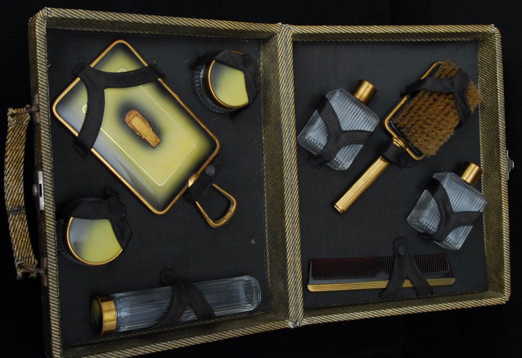 Art Deco Traveling Toiletries in Fitted Case: Including bottles, jars, hand mirror, comb and brush, case 12" wide x 10" deep x 3.5" tall.