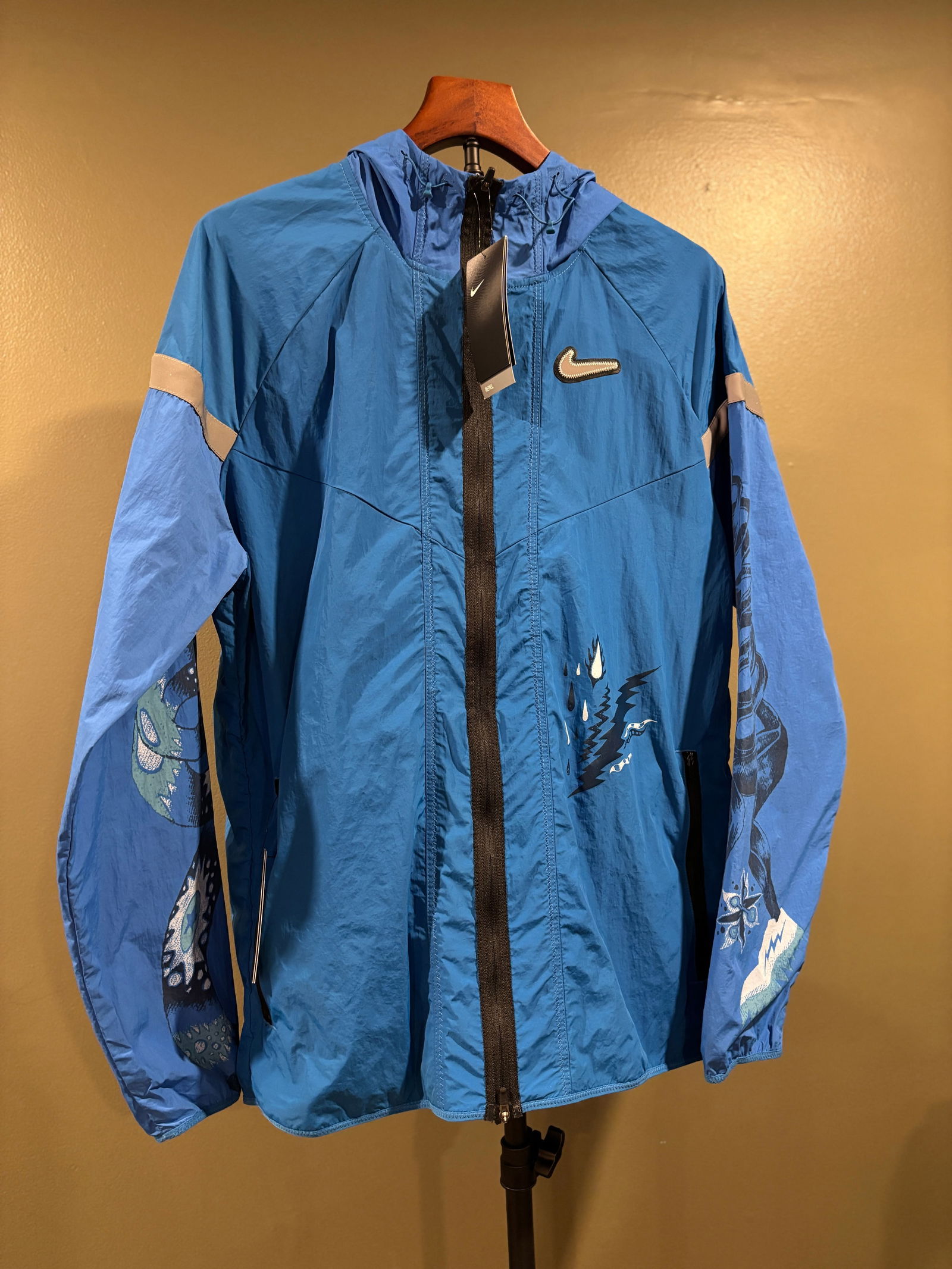 Art-Forward Nike Packable Running Jacket Men's Large: Contemporary Nike lightweight Packable hooded windbreaker featuring bold graphic artwork throughout the front, back, sleeves, and hood with themes of celestial bodies and stormy weather. Full zip, Pac