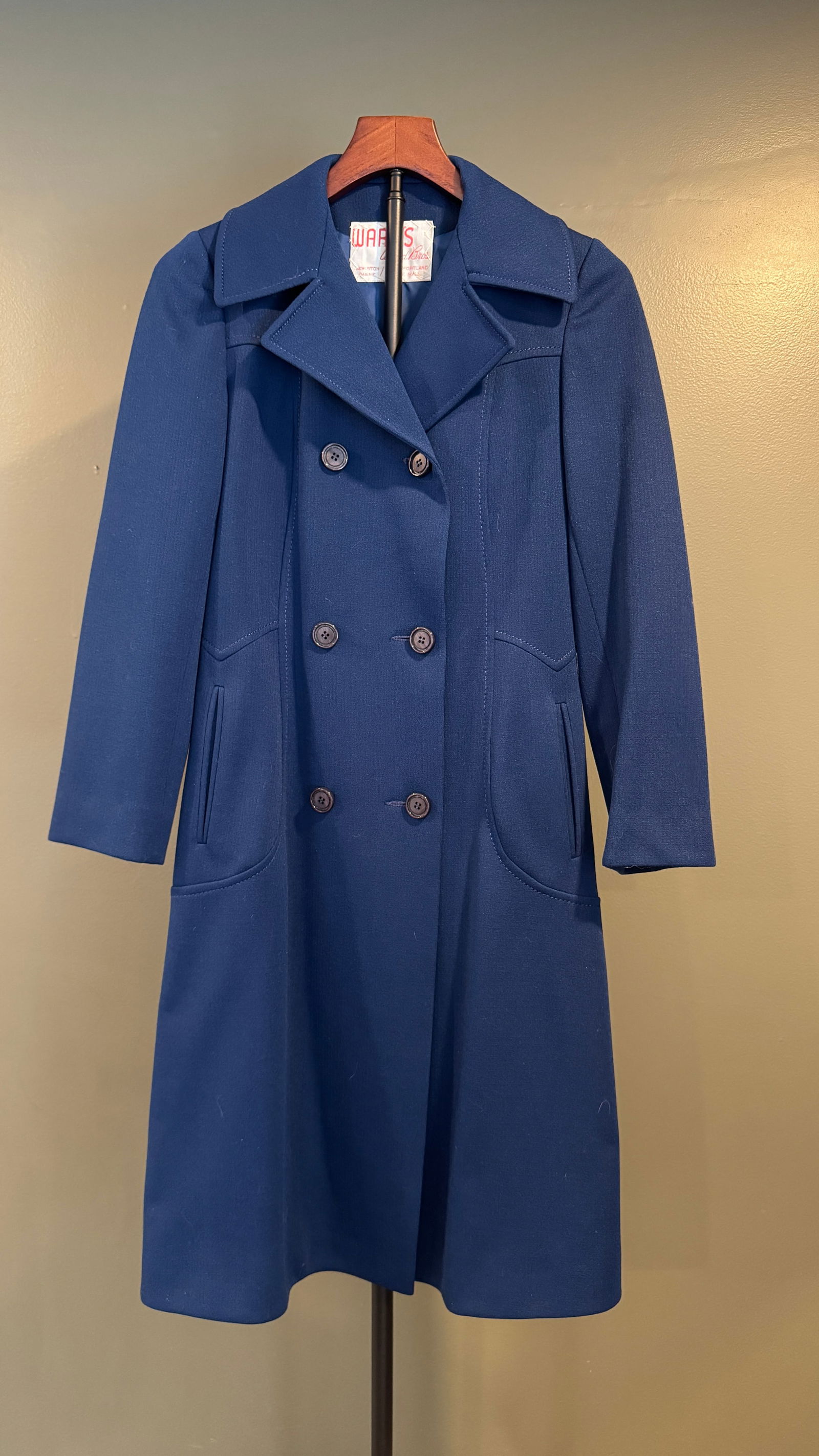 Ward's Vintage Blue Wool Coat: A well-tailored vintage coat retailed by Ward's, featuring a classic double-breasted front, wide notched lapels, and a gently flared skirted silhouette. Rendered in a rich cobalt blue wool, the design
