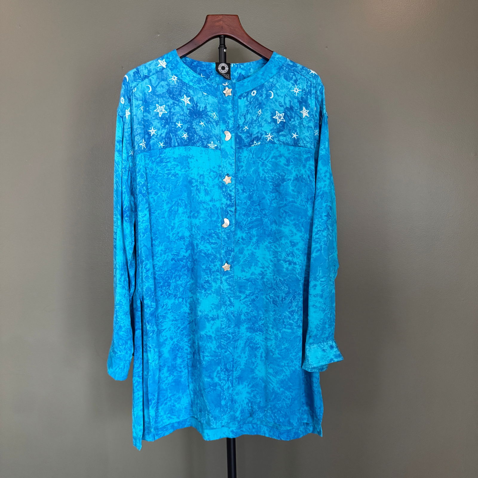 Kitavi Blue Celestial Print Rayon Tunic with Novelty Buttons: Flowing women's tunic by Kitavi, rendered in rich oceanic blue tones with an allover celestial motif of stars and moons. Crafted in lightweight woven rayon, the piece features a relaxed silhouette and