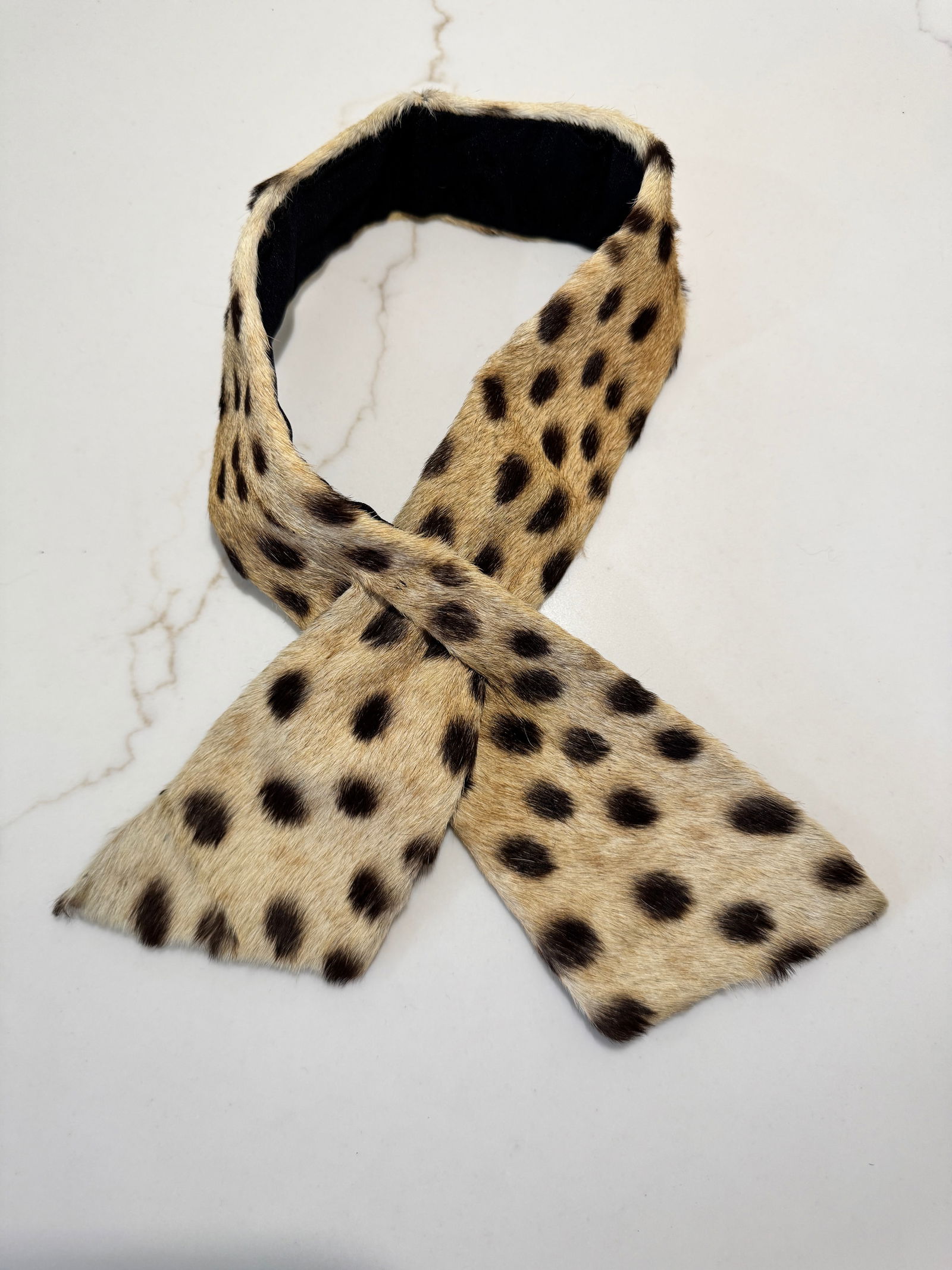 Vintage Spotted Fur Neck Scarf / Collar: A chic vintage fur neck scarf featuring a natural spotted pattern with a black fabric backing and slit-through closure. Narrow and elongated in form, designed to wrap and secure elegantly at the neckl