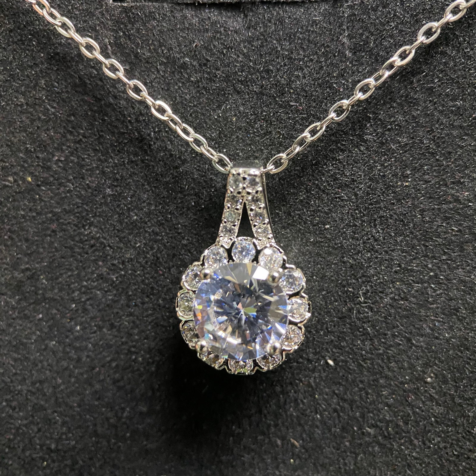 Classic Round-Cut Moissanite Pendant Necklace: A timeless and elegant necklace featuring a brilliant round-cut moissanite gemstone. The pendant is held in a secure four-prong mounting that allows for maximum light reflection, suspended from a deli