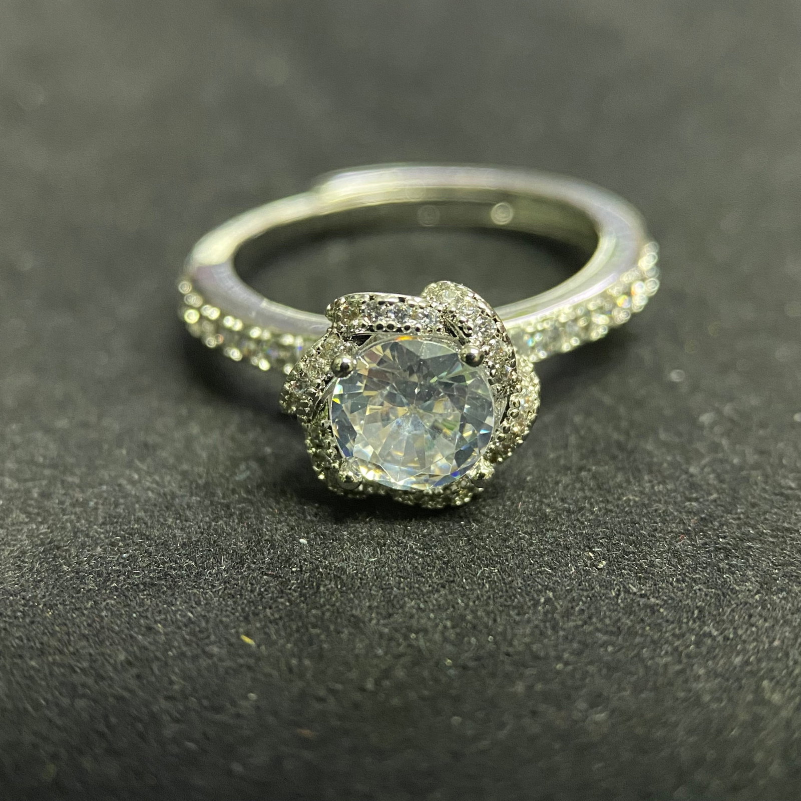 Classic Round-Cut Moissanite Solitaire Ring: An elegant solitaire ring featuring a brilliant round-cut moissanite gemstone. The stone is set in a traditional six-prong mounting on a polished silver-tone band, a timeless design that highlights th