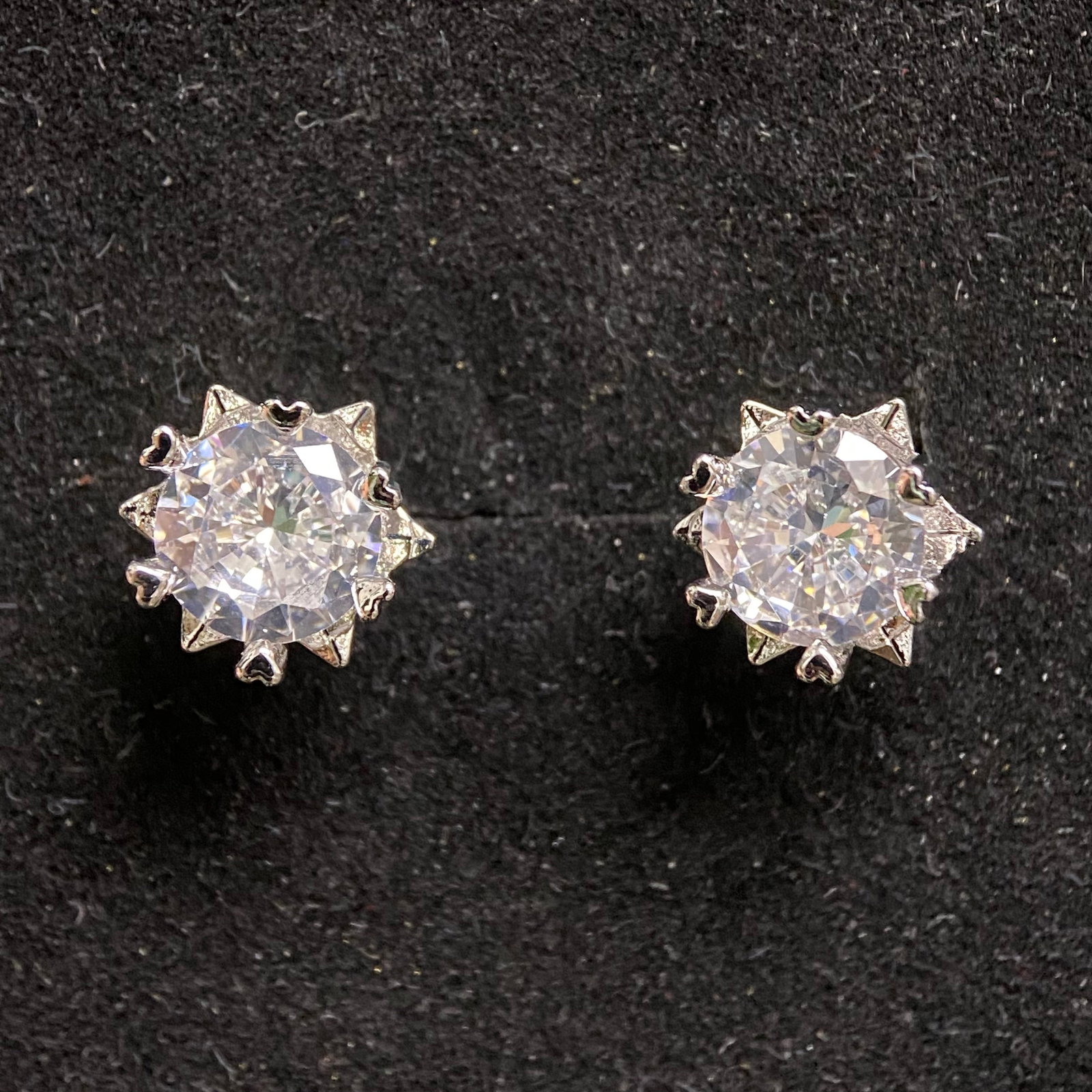Pair of Round Brilliant Stud Earrings – 1.0ct D Color, 6.5mm – GRA Certified Moissanite: Elegant pair of round brilliant-cut stud earrings, each featuring a 6.5mm stone weighing approximately 1.0 carat, D color grade. Set in silver-tone multi-prong settings that showcase the exceptional b