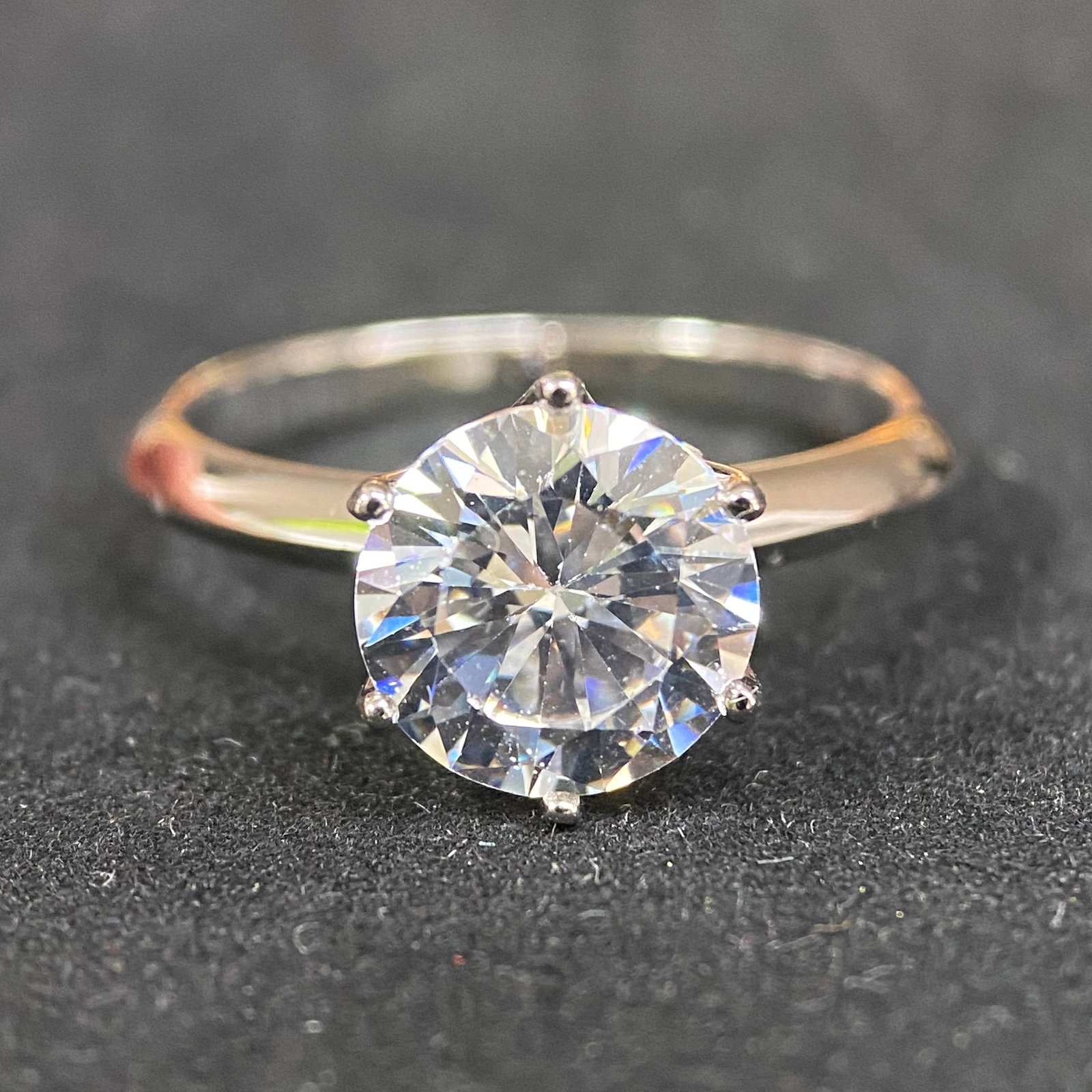 Moissanite Ring – 1.0ct D Color, 6.5mm Round Brilliant – GRA Certified. Classic 4-Prong Bridge: This elegant solitaire ring features a 1.0-carat round brilliant moissanite center stone, securely held by four high-polished prongs in a raised bridge-style setting. The elevated gallery is designed