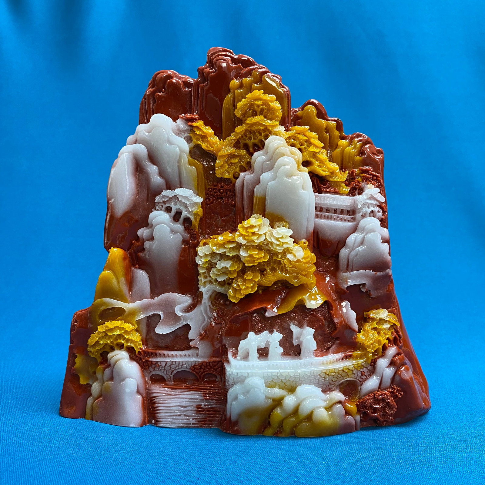 Intricate Mountain Landscape Agate Carving: This stunning piece is a masterwork of high-relief stone carving, expertly utilizing the natural tri-color banding of a substantial agate specimen. The artisan has skillfully transformed the stone's o