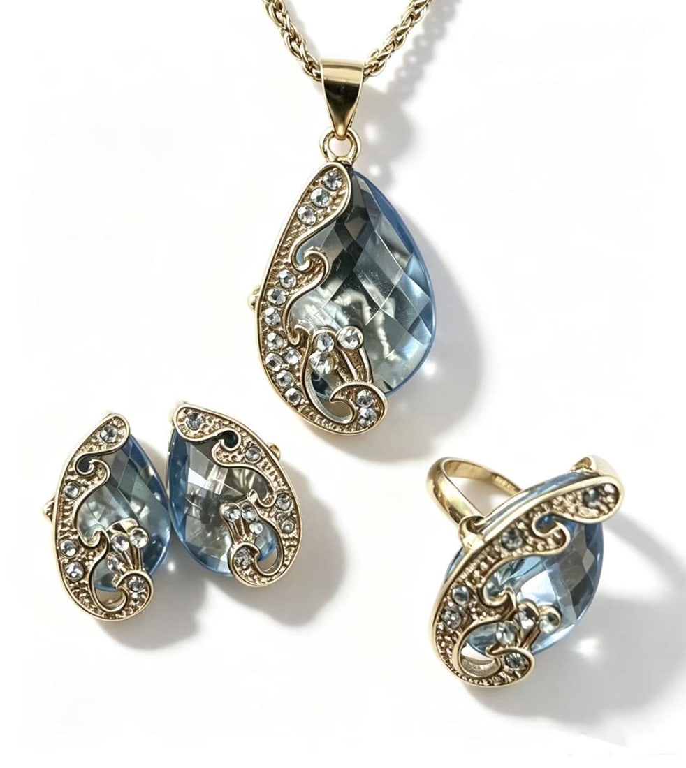 Blue Crystal Gold-Gilded Jewelry Set: Jewelry set featuring blue crystal elements accented with gold-gilded metal details and decorative clear stone embellishments. Elegant vintage-inspired design.