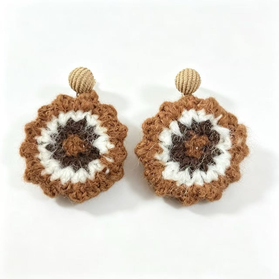 Handcrafted Crochet Floral Drop Earrings: Pair of handcrafted floral-style drop earrings featuring crocheted yarn detailing in brown, cream, and dark brown tones with textured woven tops. Bohemian-inspired contemporary fashion accessory.