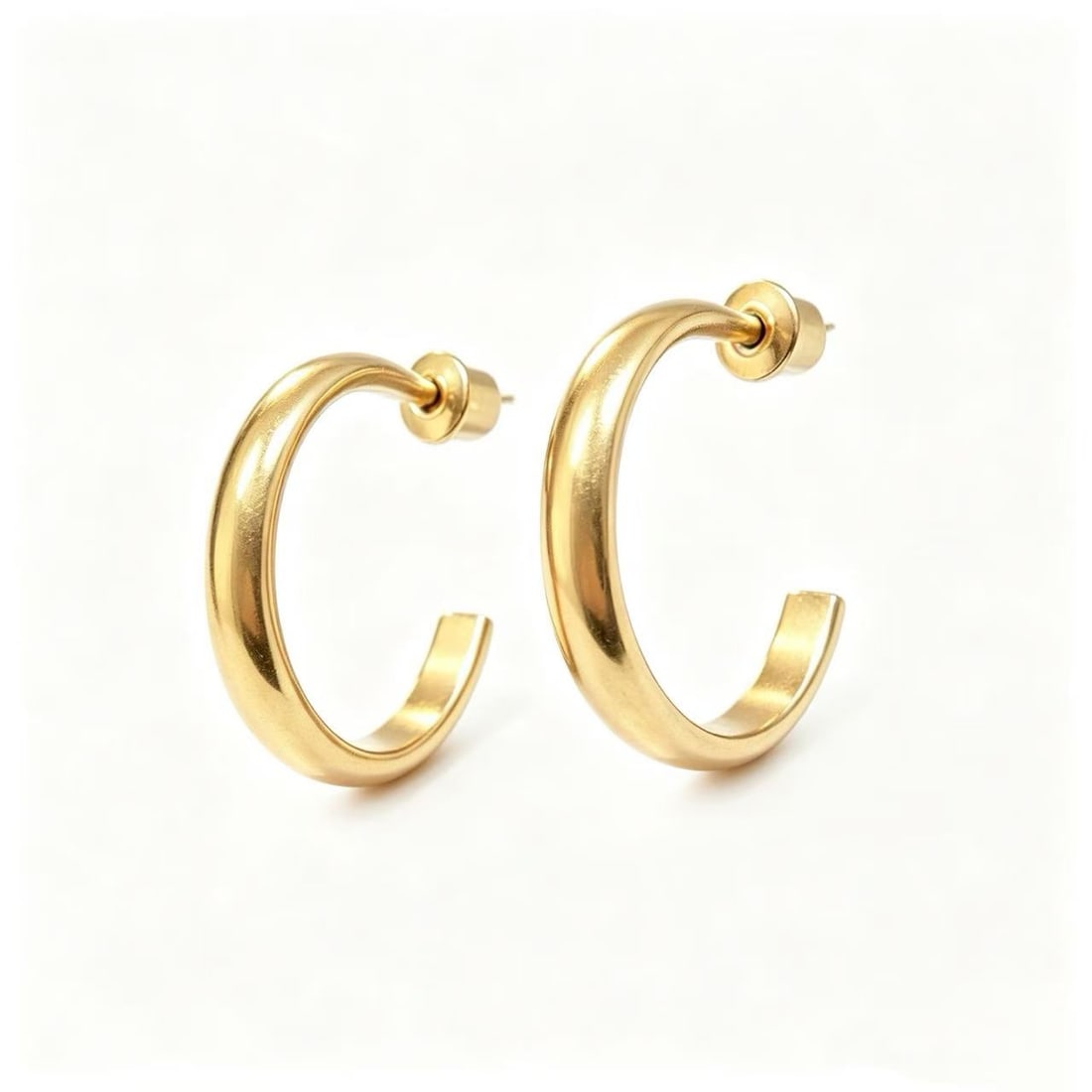 Gold-Gilded Hoop Earrings: Pair of contemporary hoop earrings featuring a clean, rounded silhouette and polished gold-gilded finish. The minimalist design offers a versatile look suitable for everyday wear, modern fashion