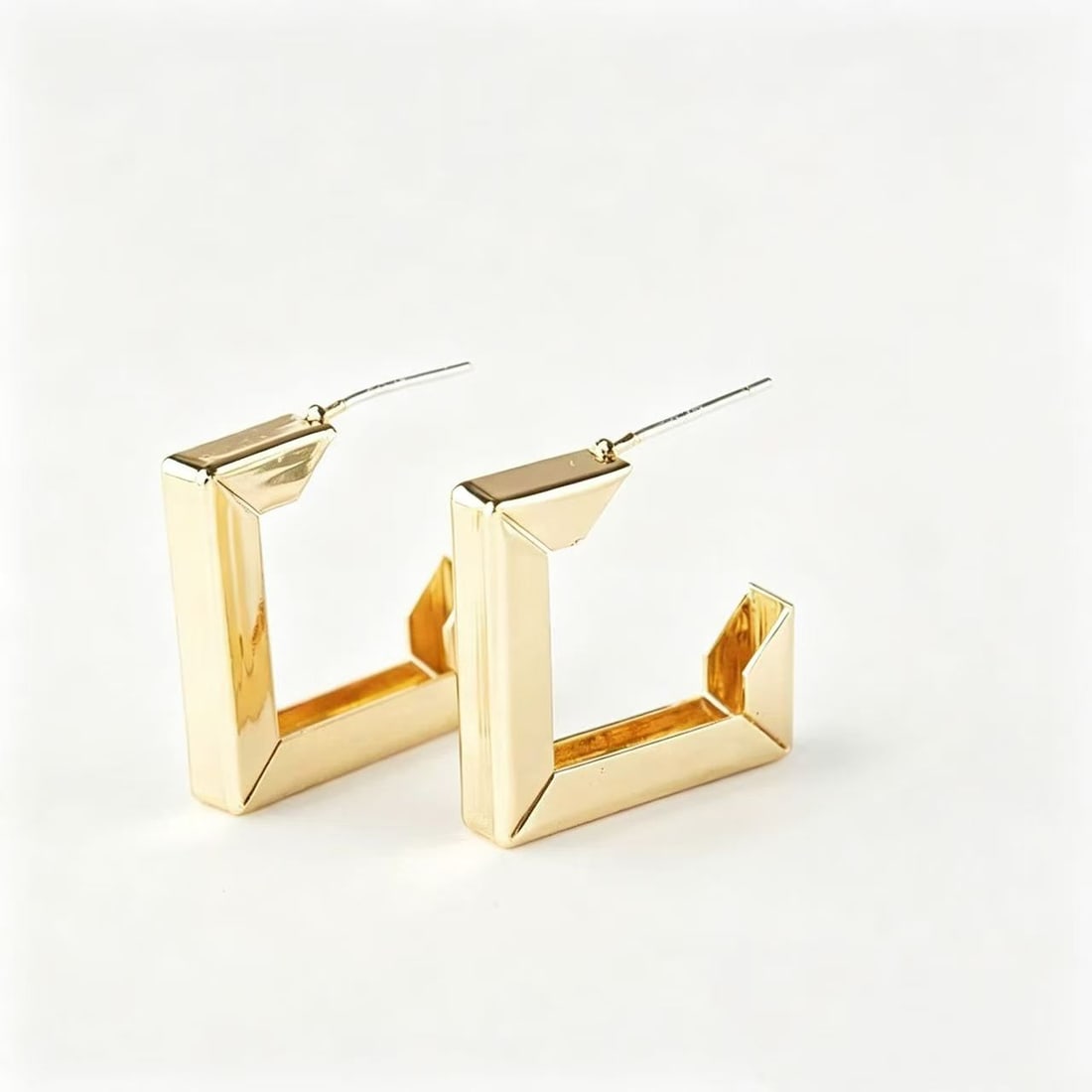 Gold-Gilded Geometric Hoop Earrings: Pair of contemporary geometric hoop earrings featuring an angular square-form open design with polished gold-gilded surfaces. Modern minimalist style suitable for casual or formal wear.