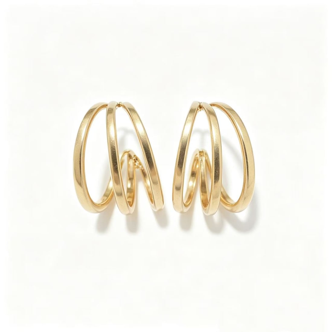 Gold-Gilded Double Hoop Earrings: Pair of contemporary double hoop earrings featuring an overlapping open-circle design with polished gold-gilded finish. Modern minimalist styling with layered hoop construction suitable for casual wea