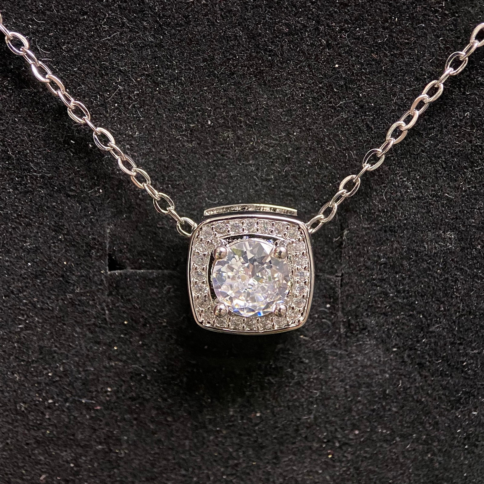 1.0ct Moissanite Cushion Halo Pendant III, 925: Indulge in vintage-inspired luxury mixed with contemporary geometric design with this breathtaking round brilliant-cut moissanite cushion halo pendant necklace. Masterfully crafted from high-quality 9