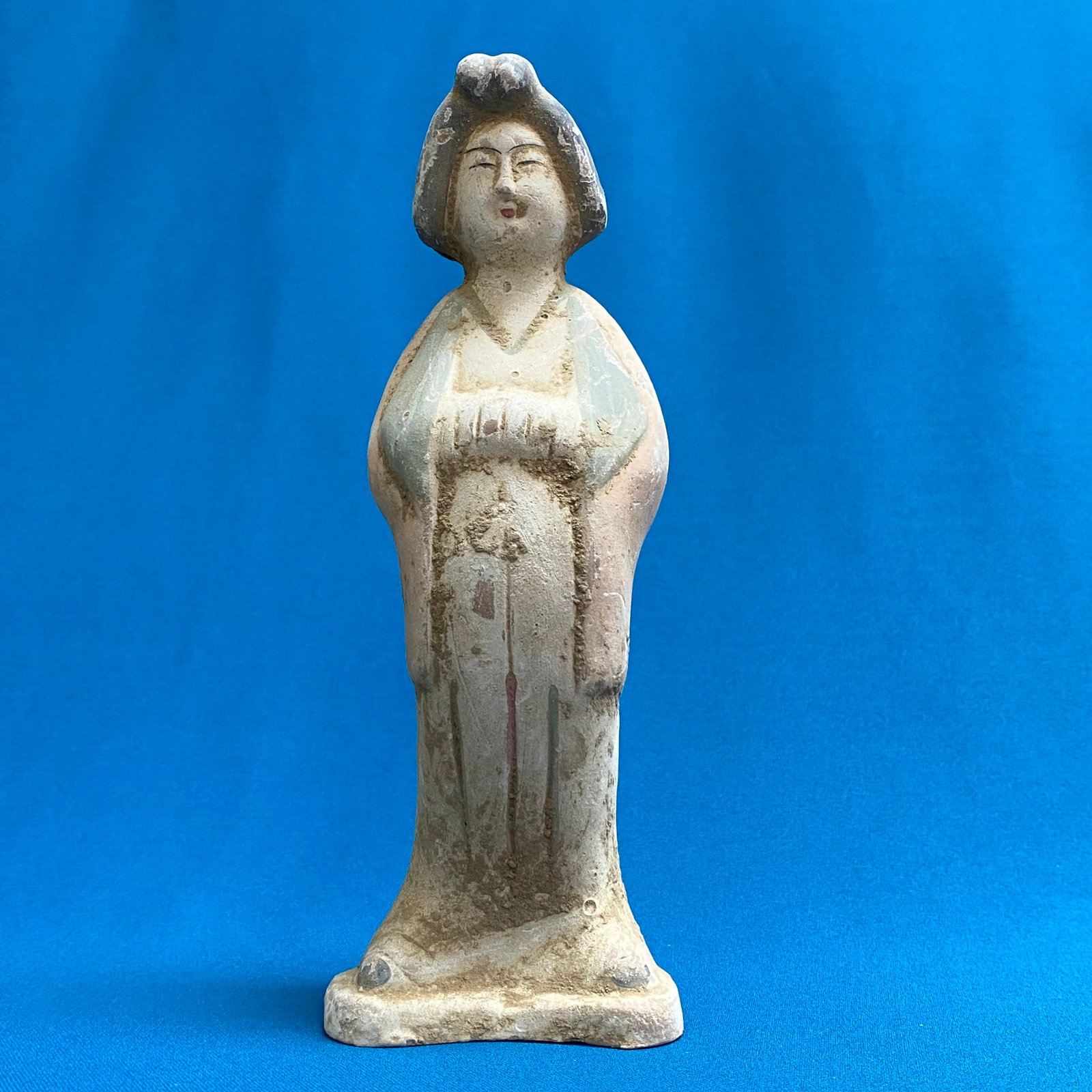 Chinese Tang-Style Painted Pottery Court Lady Figurine: This terracotta pottery figurine depicts a standing court lady or female attendant in the classic style of the Tang dynasty. The figure is modeled with her hands elegantly clasped together beneath the