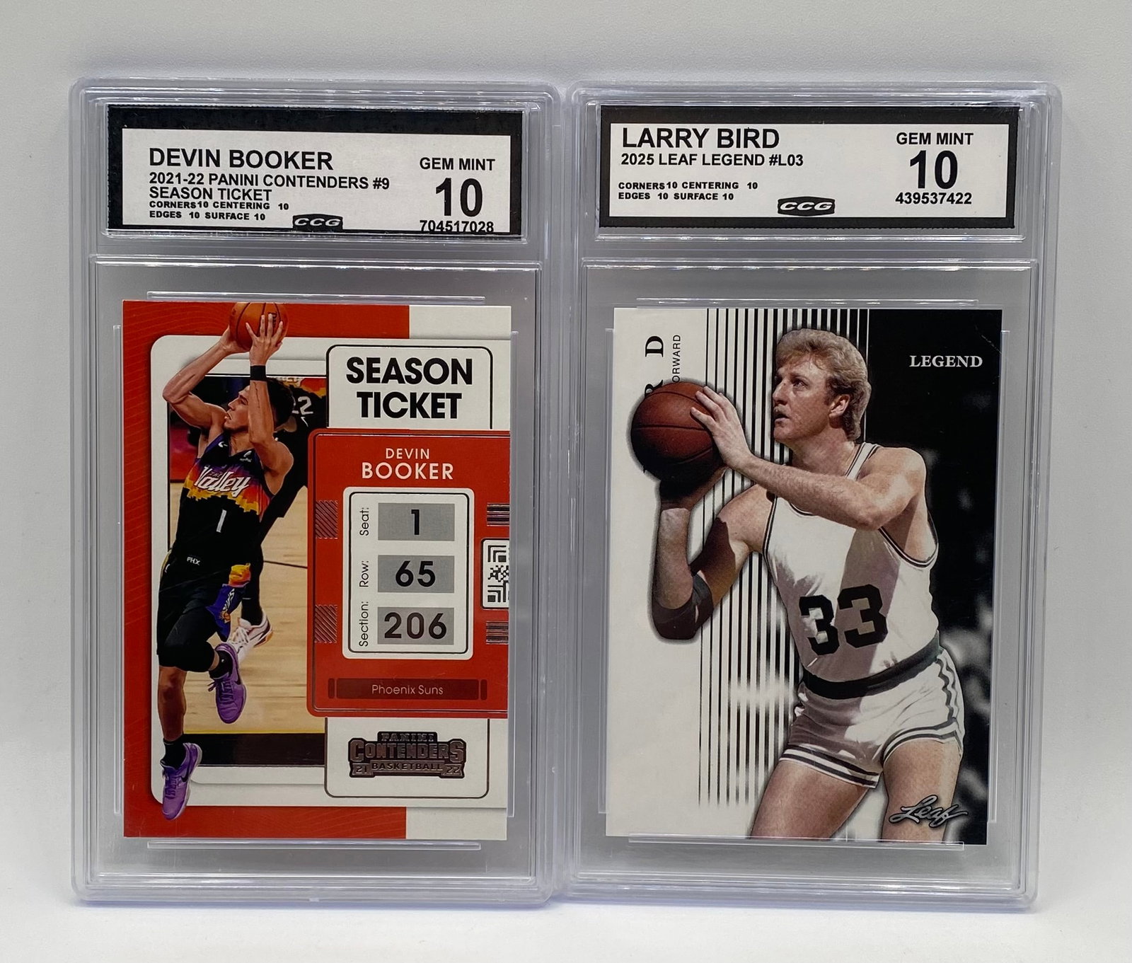 (2) NBA CCG 10 Lot: 2021-22 Contenders D. Booker & 2025 Leaf L. Bird: Modern and vintage legend combination, both graded CCG Gem Mint 10: 2021-22 Panini Contenders Devin Booker Season Ticket #9 (CCG 10 - Subgrades: 10/10/10/10) 2025 Leaf Legend Larry Bird #L03 (CCG 10 -
