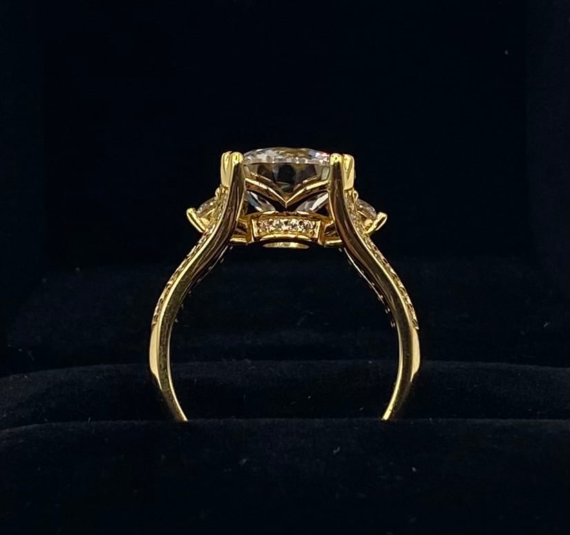 5 Ct VVS Cathedral Ring | 18K Yellow Gold Plated 925 Silver: A grand three-stone configuration highlighting a prominent round moissanite flanked by brilliant side stones and hidden halo pavé detailing. Plated in warm 18K yellow gold over solid 925 sterling sil