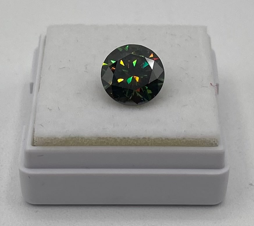 3.00 CT Fancy Dark Green VVS1 Round Brilliant Cut Moissanite: Main Stone: Moissanite Shape / Cut: Round Brilliant Cut Carat Weight: 3.00 CT Color Grade: Fancy Dark Green / Black Clarity Grade: VVS1 Condition: Excellent / New in display box Overview: A striking 3