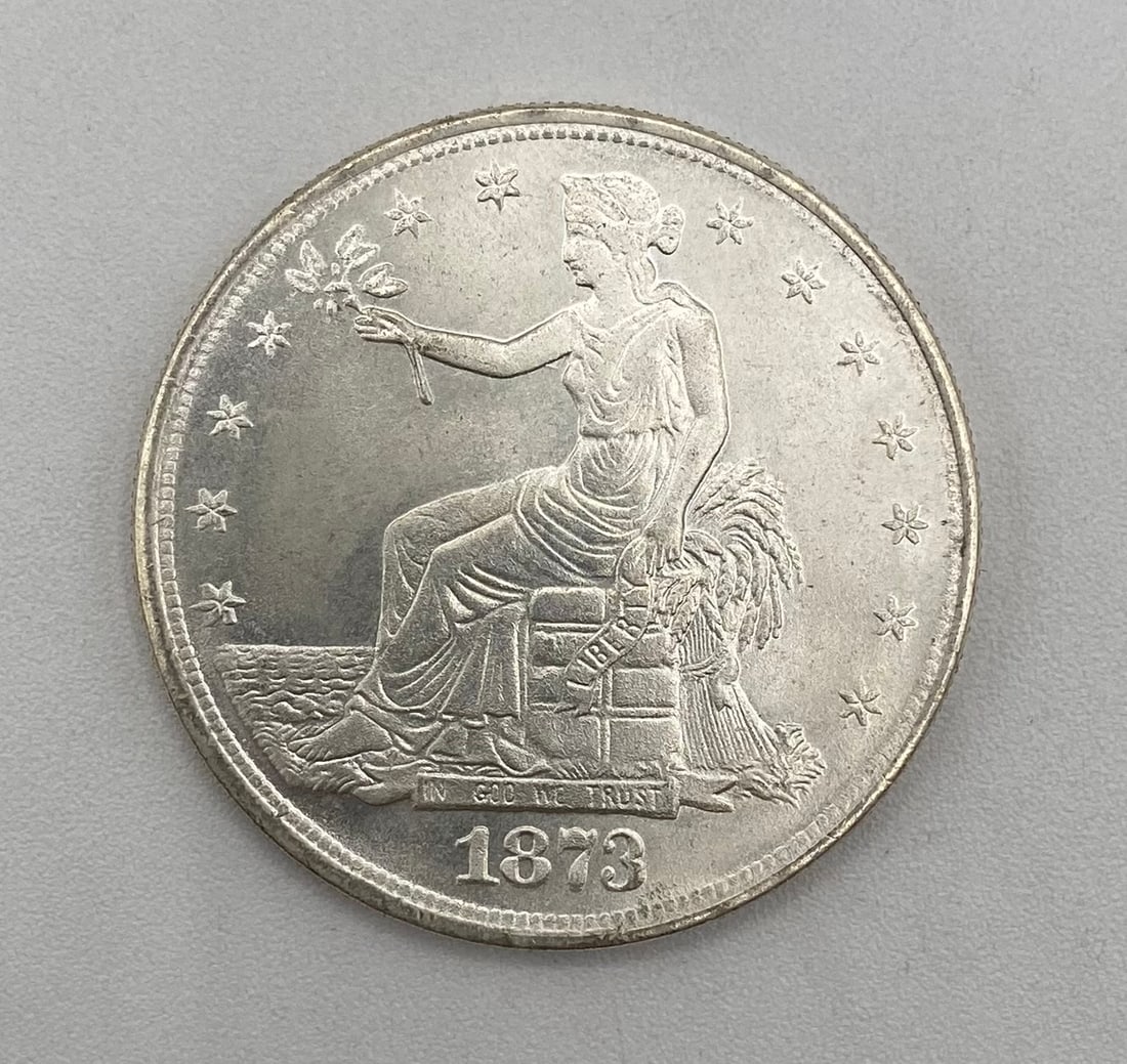 1873 Trade Dollar Design Silver Round / Tribute Token: Design: Obverse featuring Lady Liberty seated on trade bales facing left, holding an olive branch, with "IN GOD WE TRUST" banner and dated 1873. Type: Collector Silver Round / Replica Coin Composition