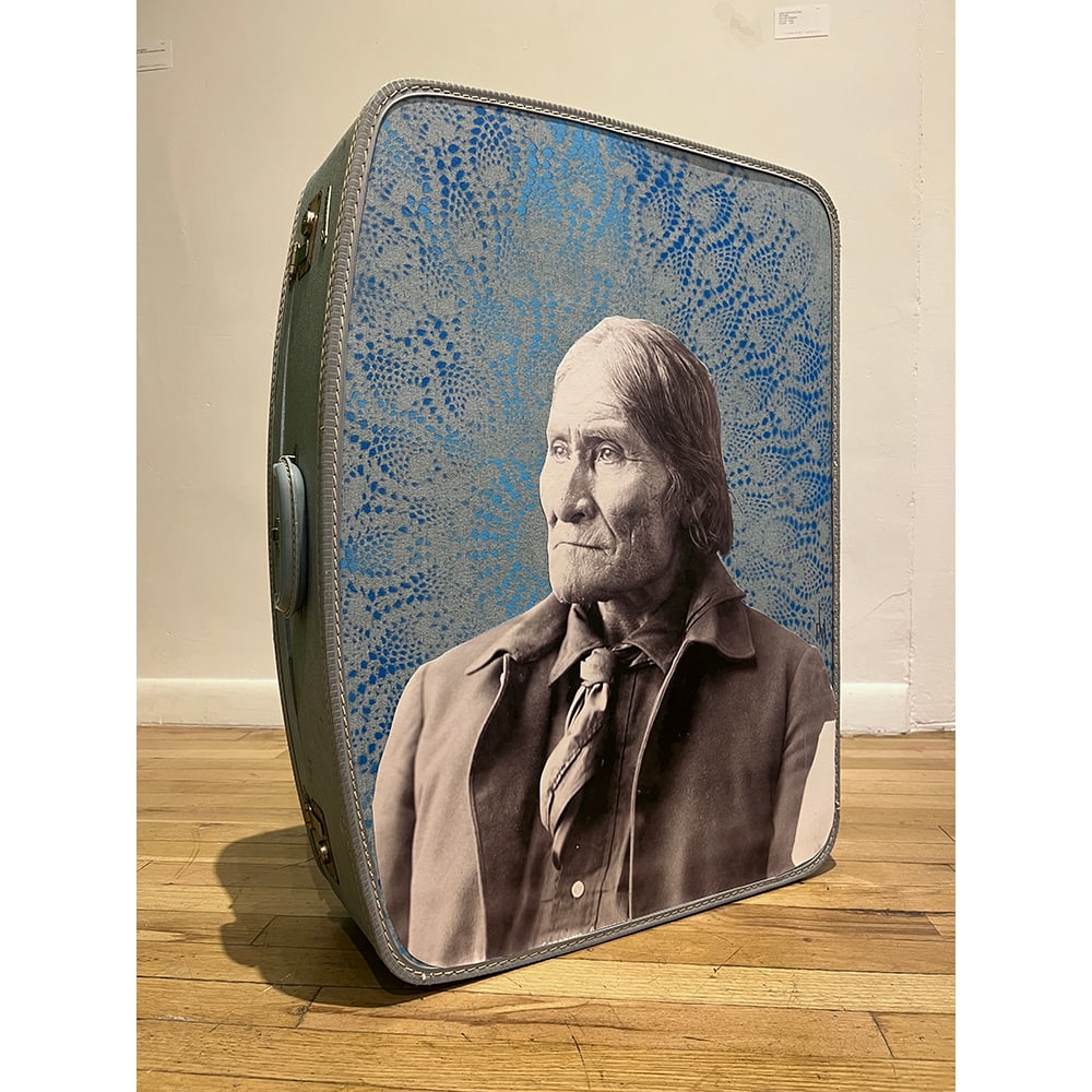 Douglas Miles, Forced Removal Series: Geronimo in Blue: Douglas Miles created a series of silkscreen images of great Apache leaders and placed them —with grand spray painted stencil designs—on suitcases. This is significant due to the analogy of Apache