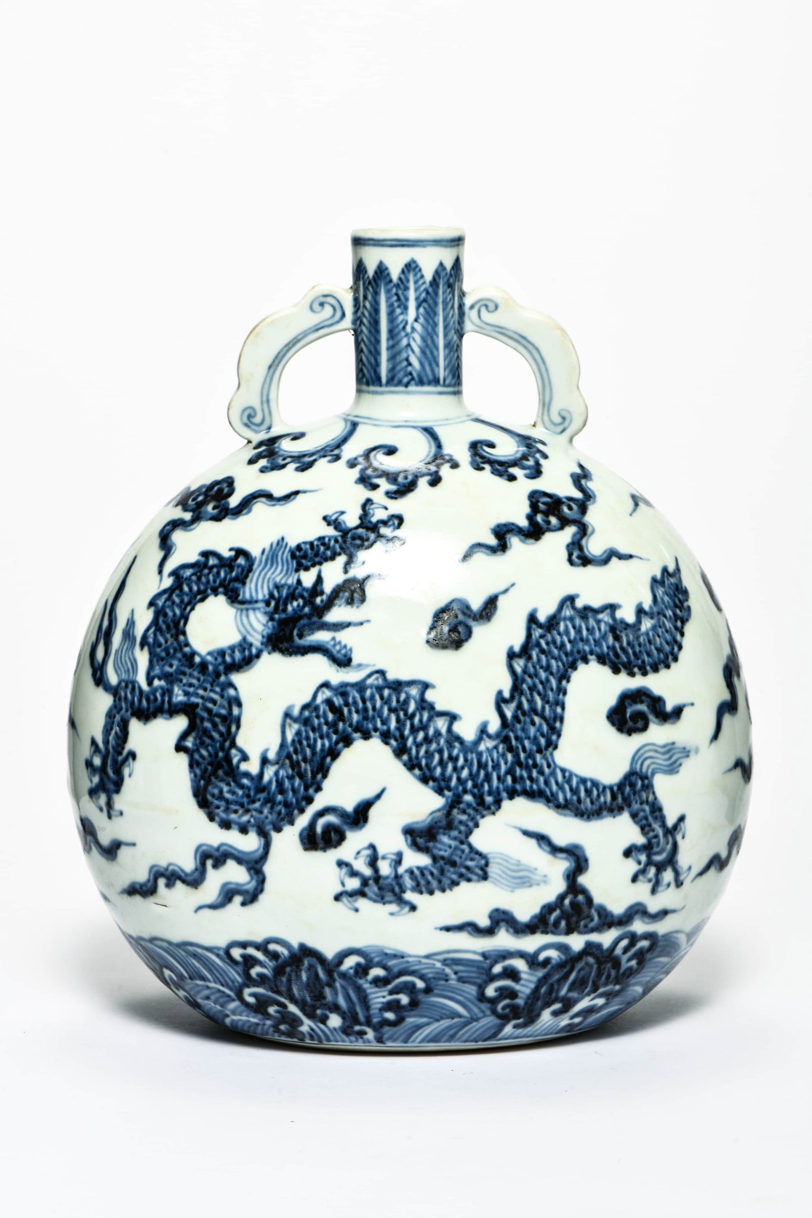 A BLUE AND WHITE 'DRAGONS IN WAVES' MOONFLASK: A BLUE AND WHITE 'DRAGONS IN WAVES' MOONFLASK Description: Length: 21.2 cm Height: 27 cm