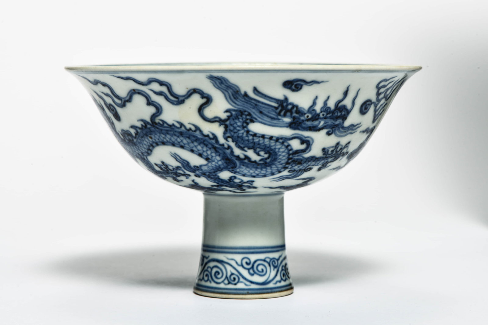 A BLUE AND WHITE 'DRAGONS CHASING PEARL' STEM BOWL: A BLUE AND WHITE 'DRAGONS CHASING PEARL' STEM BOWL Description: Width: 15.5 cm Height: 10 cm