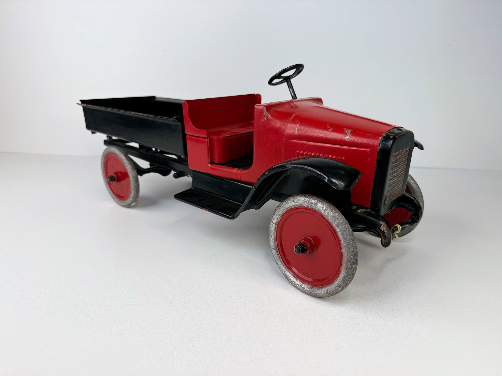 Restored 1920's Buddy L pressed Steel Dump Truck: Nicely Restored 1920s Buddy-L Pressed Steel Chain Lift Dump Truck featuring quality restoration with an attractive finish. Equipped with the classic chain-operated dump bed and retaining excellent vin