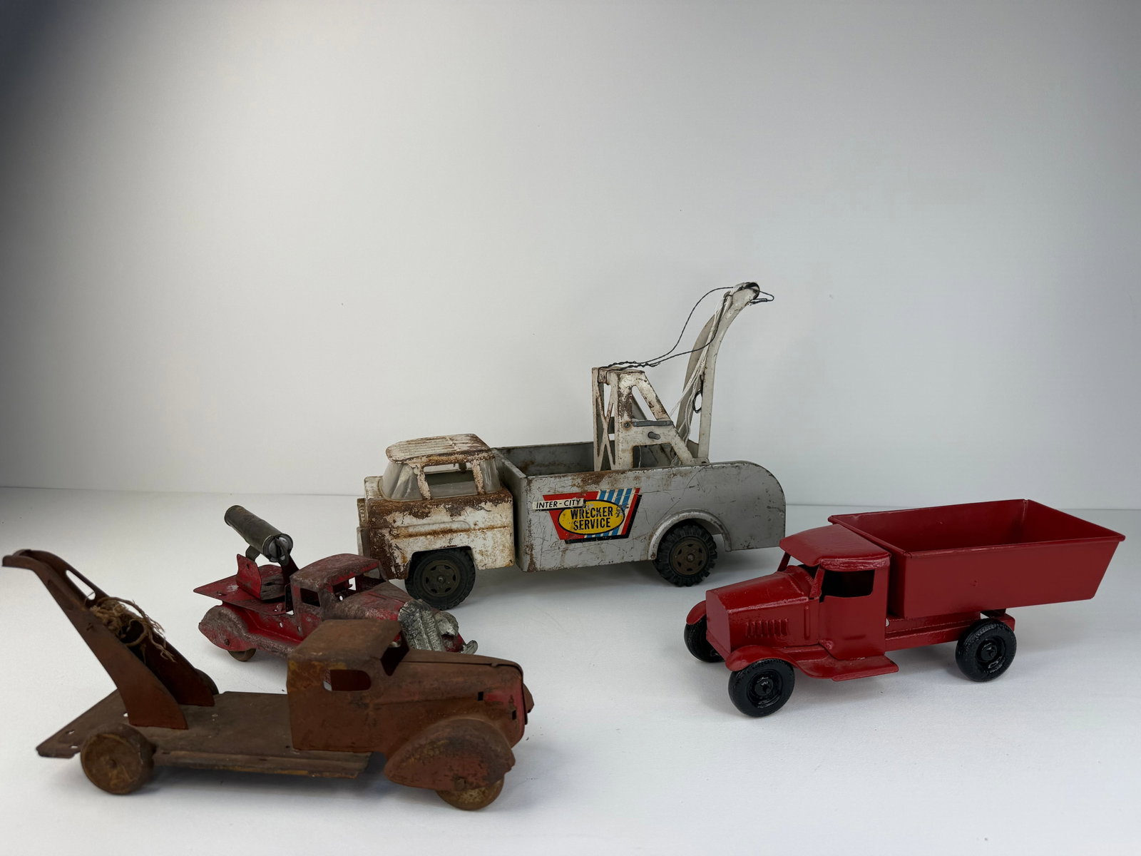 Lot of four repainted trucks: Lot of four vintage pressed steel trucks. Includes four trucks of various sizes, makers, and conditions, with some examples having been repainted. A great assortment for collectors or display. See pic