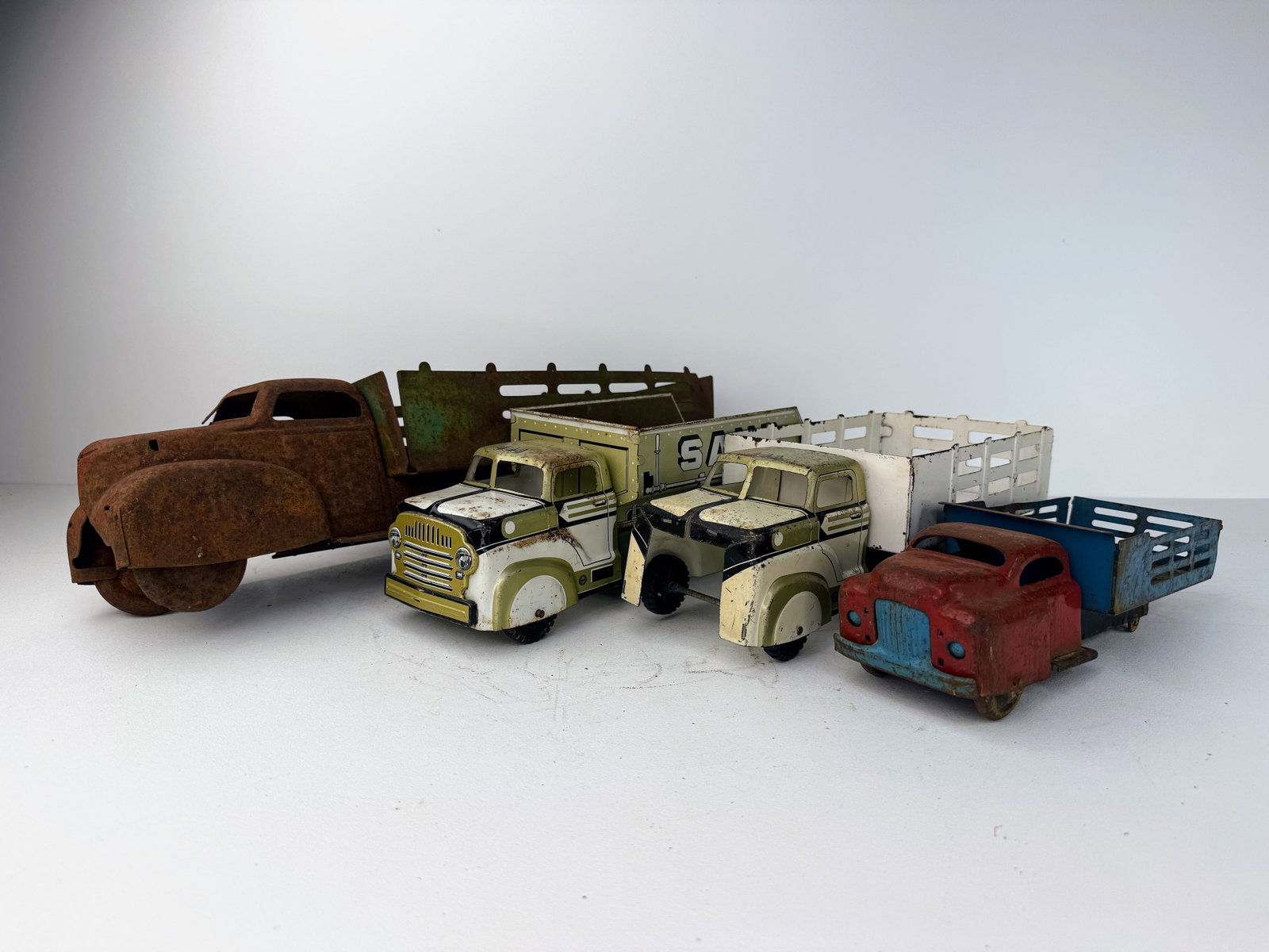 Mid-twentieth century Buddy-L sit-N-ride truck with seat: Lot of early- to mid-20th century pressed steel trucks. A great assortment of well-patinaed vintage trucks showing varying degrees of wear and damage consistent with age. An excellent group for collec