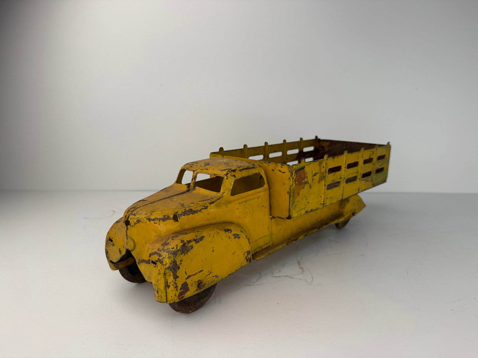 Louis Marx repainted Pressed Steel Delivery Truck: Louis Marx Pressed Steel Delivery Truck featuring an older repaint and classic vintage styling. Displays significant rust and paint loss, with damage to the rear wheels. Despite its condition, it rema