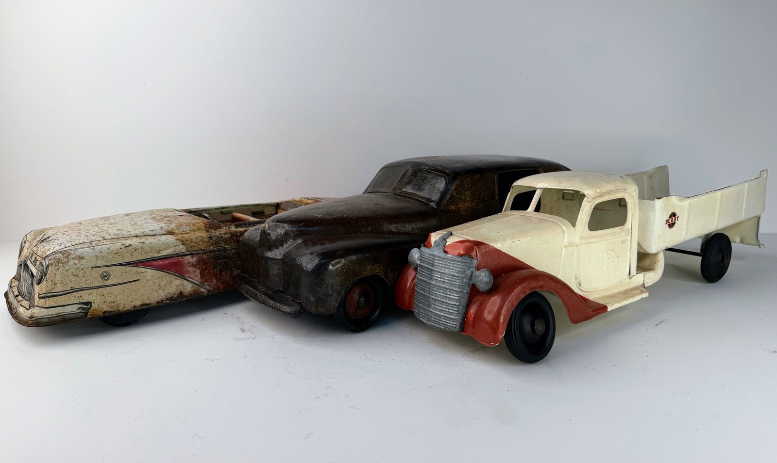 Lot of three cars and trucks: Lot of three vintage toys including a Buddy L pressed steel truck, a 1940s Wyandotte Toytown "Woody" Estate car, and a heavily patinaed Marx Sportster car. A great assortment of classic vintage toys. 