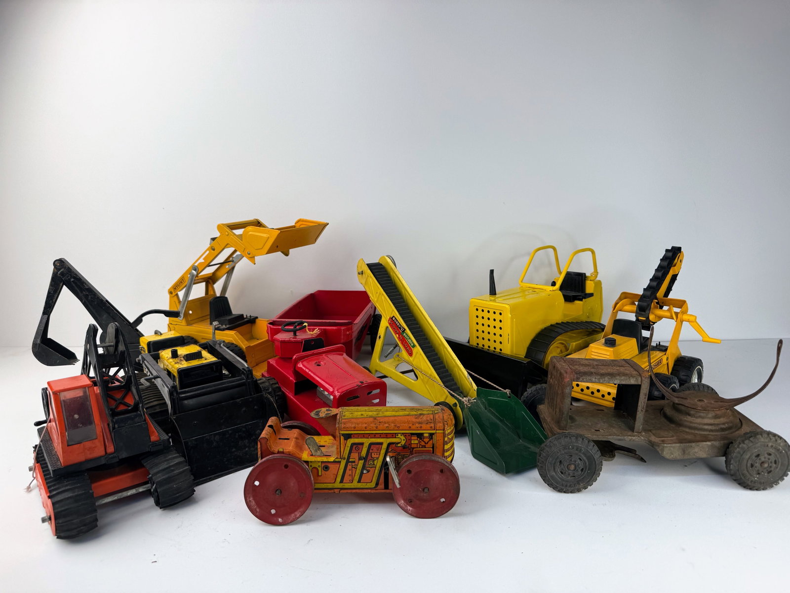 Large assortment of newer toy machinery: Large assortment of toy construction machinery including bulldozers, trenchers, backhoes, and skid steers. All pieces are in good overall condition, making this a great lot for collectors or play. See