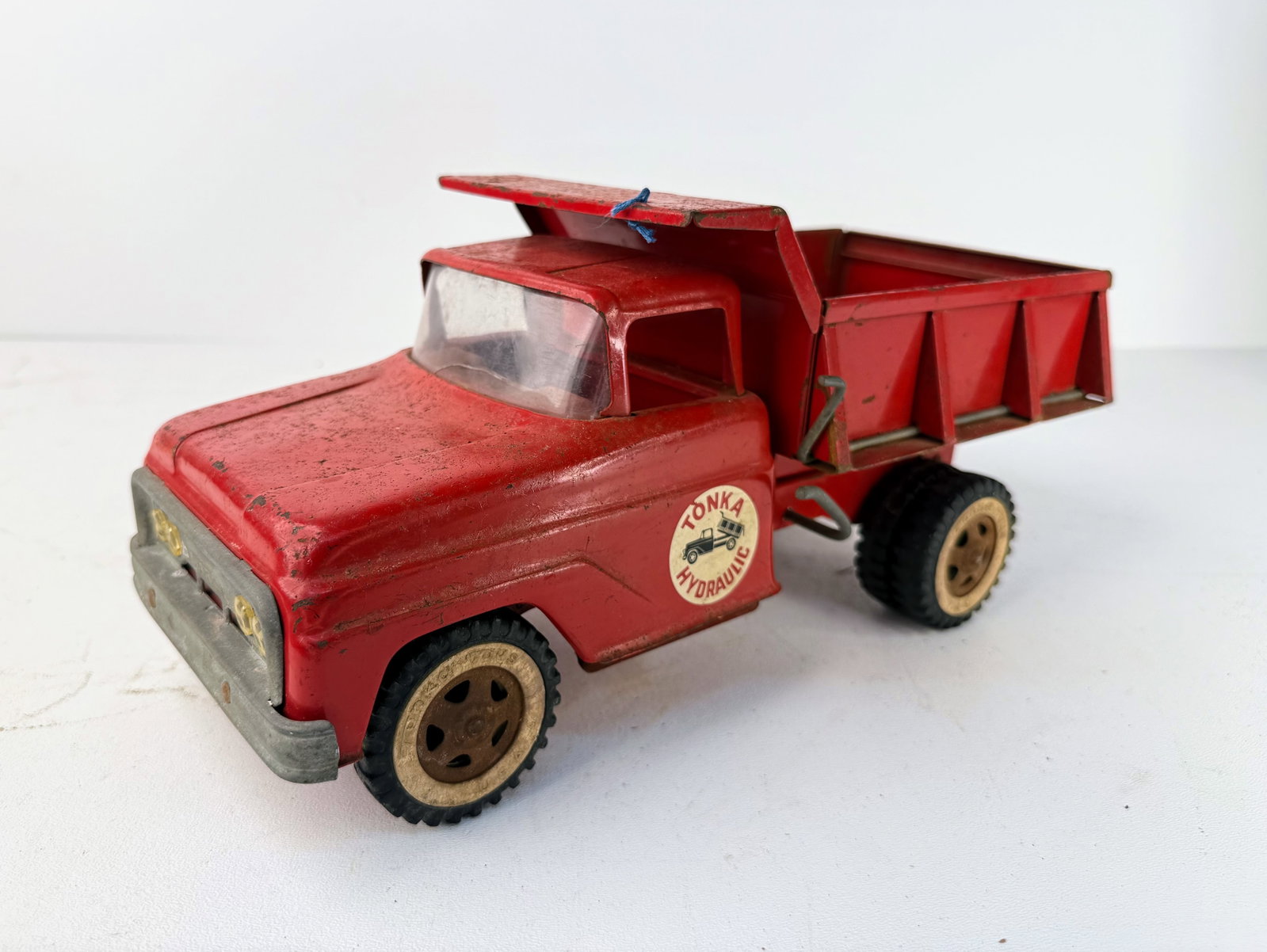 Repainted 1960s pressed steel Tonka dump truck: Repainted 1960s Tonka pressed steel dump truck. This vintage dual-wheel hydraulic dump truck has been repainted and remains in good overall condition. A great example of a classic Tonka construction