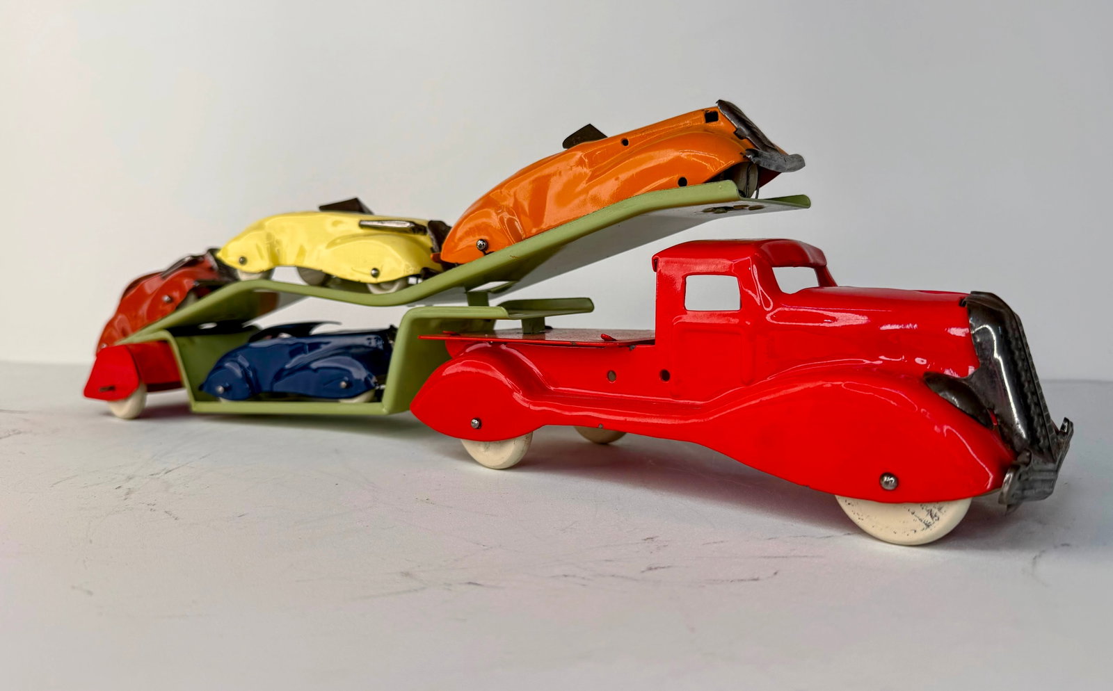 Louis Marx pressed steel auto transport hauler: Louis Marx Pressed Steel Auto Transport Hauler with Four Cars in great overall condition. The transport truck has lost most of its original tires, while all four accompanying cars remain in very good 