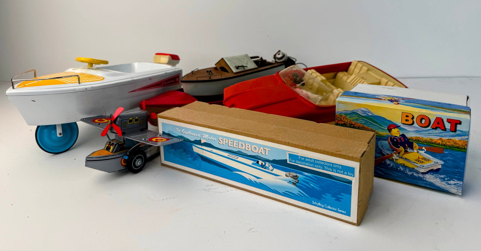 Assorted lot of boats and other water craft: Assorted lot of boats and watercraft. This fun assortment includes several vintage toy boats, including a new old stock boat in its original box and an outboard speedboat with its original box. A grea