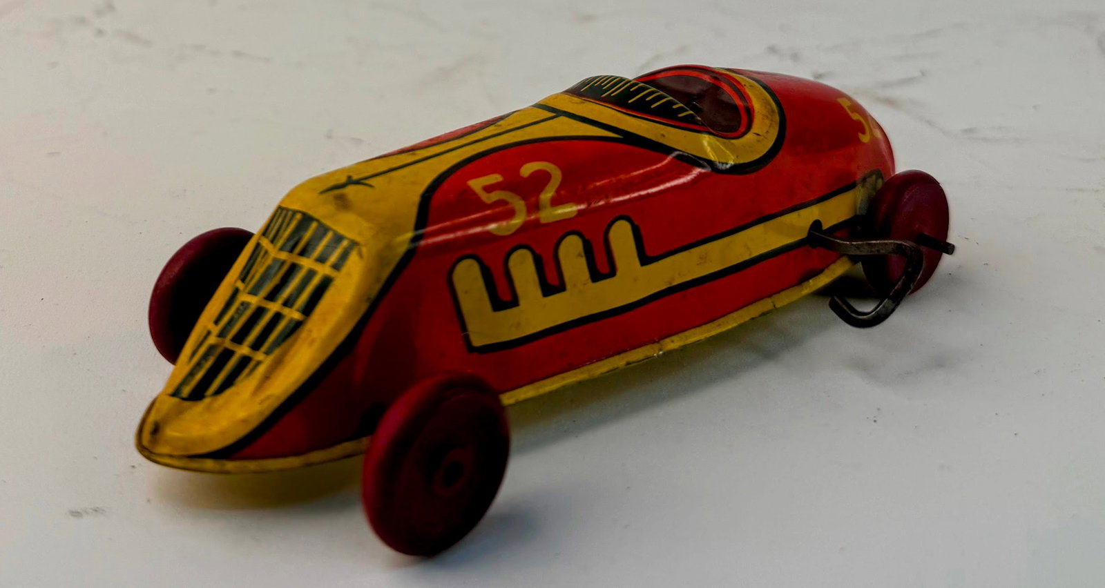 J Chein single engine tin litho wind-up race car: J. Chein single-engine tin lithographed wind-up race car. This colorful No. 52 race car displays well despite missing several parts, and the wind-up mechanism is no longer functioning. A great vintage