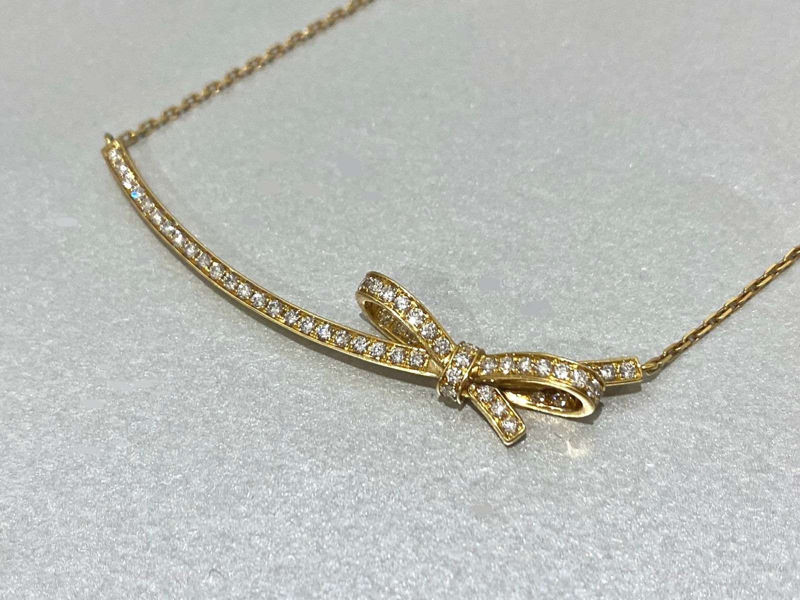 Chanel 18K Yellow Gold with Diamond Bow Motif Pendant Necklace: Condition: Like New Brand: Chanel Type: Pendant Necklace Base Metal: 18k Yellow Gold Gemstone: Diamond Total Carat Weight: 0.50CTW Clarity: VS1-VS2 Color: F Diamond count: 54 Round Brilliant Cut Diamo