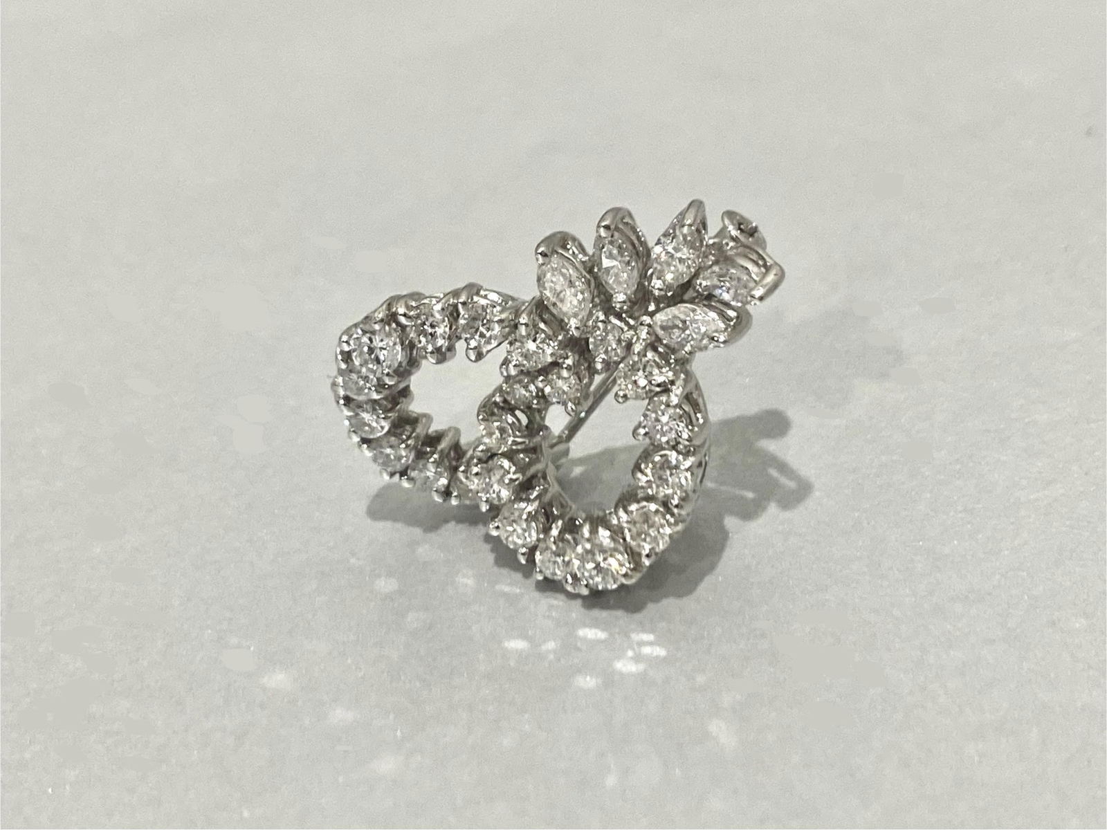 Over 2 Carats Diamond Brooch Pin in 18K White Gold: Condition: Pre-owned Brand: Unbranded Material: 18K White Gold GemStone: Diamond Diamonds: 23 round-cut diamonds AND 5 marquise-cut diamonds Total Carat Weight: Over 2 Carats Color and Clarity: F, SI1