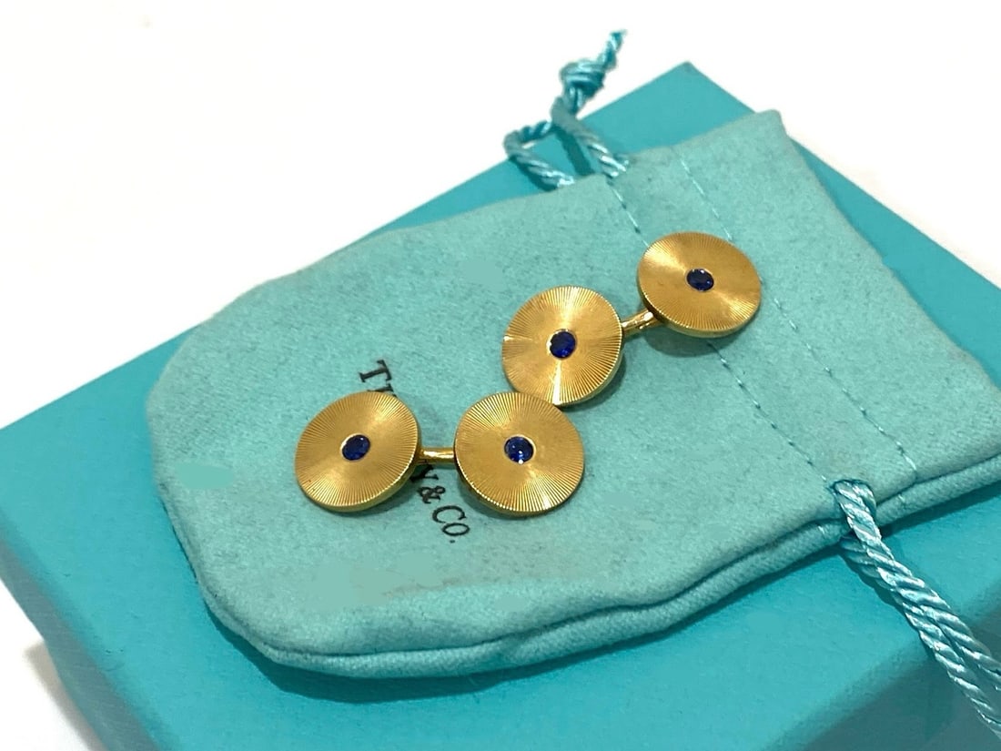 Tiffany & Co. 14K Yellow Gold and Sapphire Cufflinks: Condition: Like New Brand: Tiffany & Co. Material: 14K Yellow Gold Gemstone: Sapphire Gemstone Count: 4 Dimensions: Length: Apx 1.2" Stamp: " Tiffany & Co." "14k" Weight: 15.5 Grams Comes with an orig