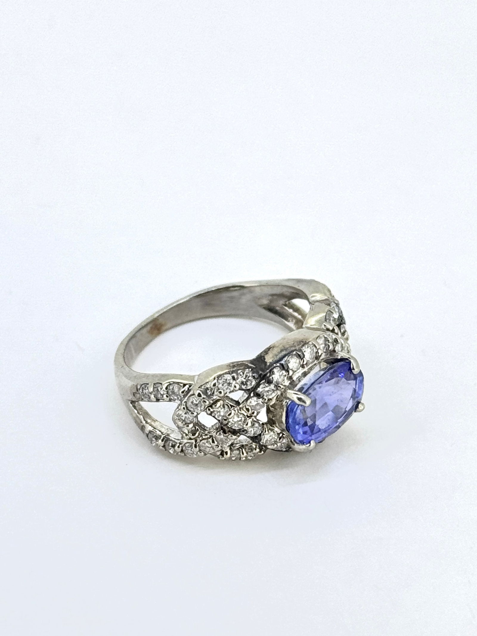 Natural Tanzanite and Round Diamond Ring in 14k White Gold: Condition: Like New. Brand: Unbranded. Material: 14k White Gold. Gemstone: Round Diamond and Tanzanite. Diamond Count: 52. Tanzanite Dimensions: 8mm Ring Size: 5.25. Weight: 4.2 grams.