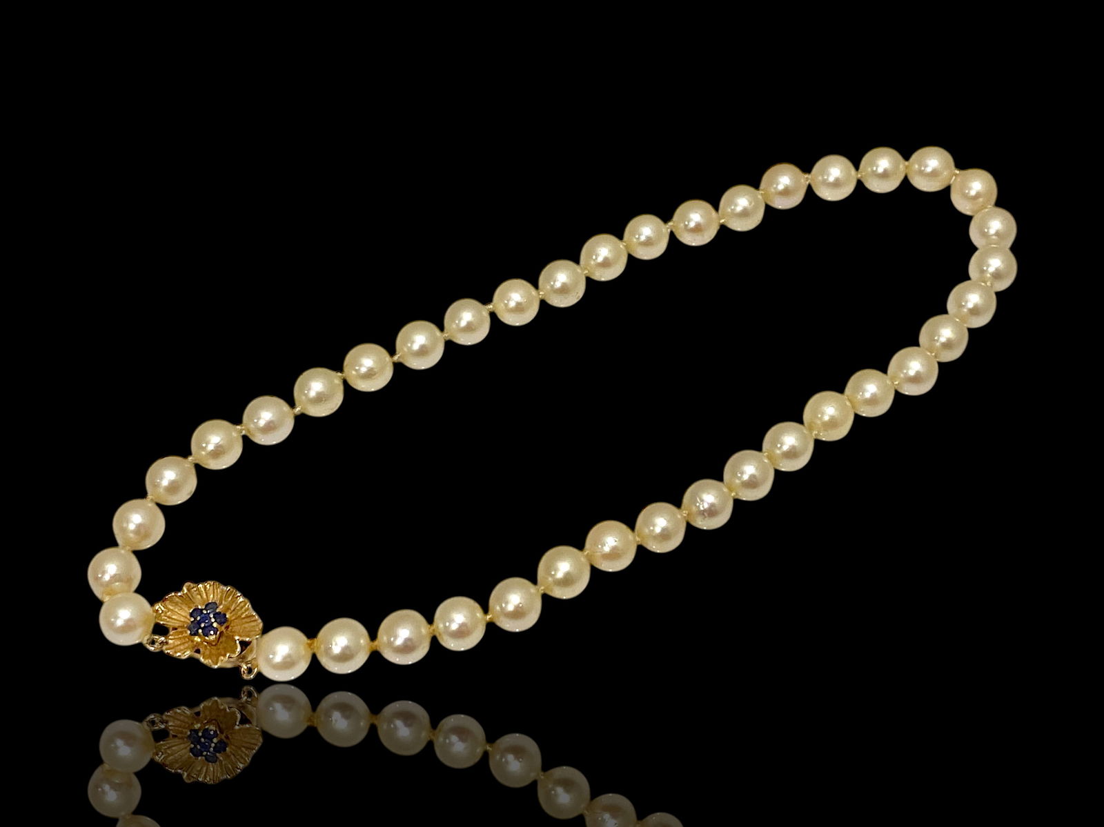 Classic Cultured Pearl Choker Necklace with 14k Gold Sapphire Clasp.: Condition: Like NewBrand: UnbrandedMaterial: 14k Yellow GoldJewel: Cultured Pearls and Blue sapphire.Pearls Count: 42.Necklace Length: 14" inchesWeight: 29.6 grams.