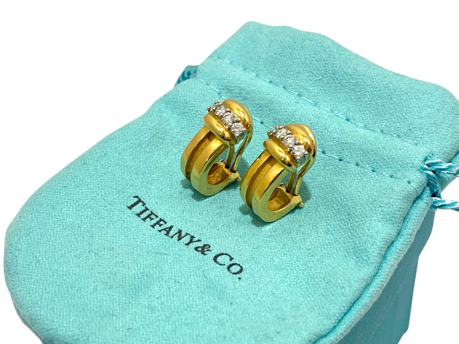 Tiffany & Co. 1995 Atlas 18k Yellow Gold and Diamond Hoop Earrings: Condition: Like New. Brand: Tiffany & Co. Metal: 18k Yellow Gold. Gemstone: Round Brilliant-cut Diamond Diamond Count: 8. Earrings Dimensions: Length: 0.8" Width: 0.5". Weight: 10.6 grams
