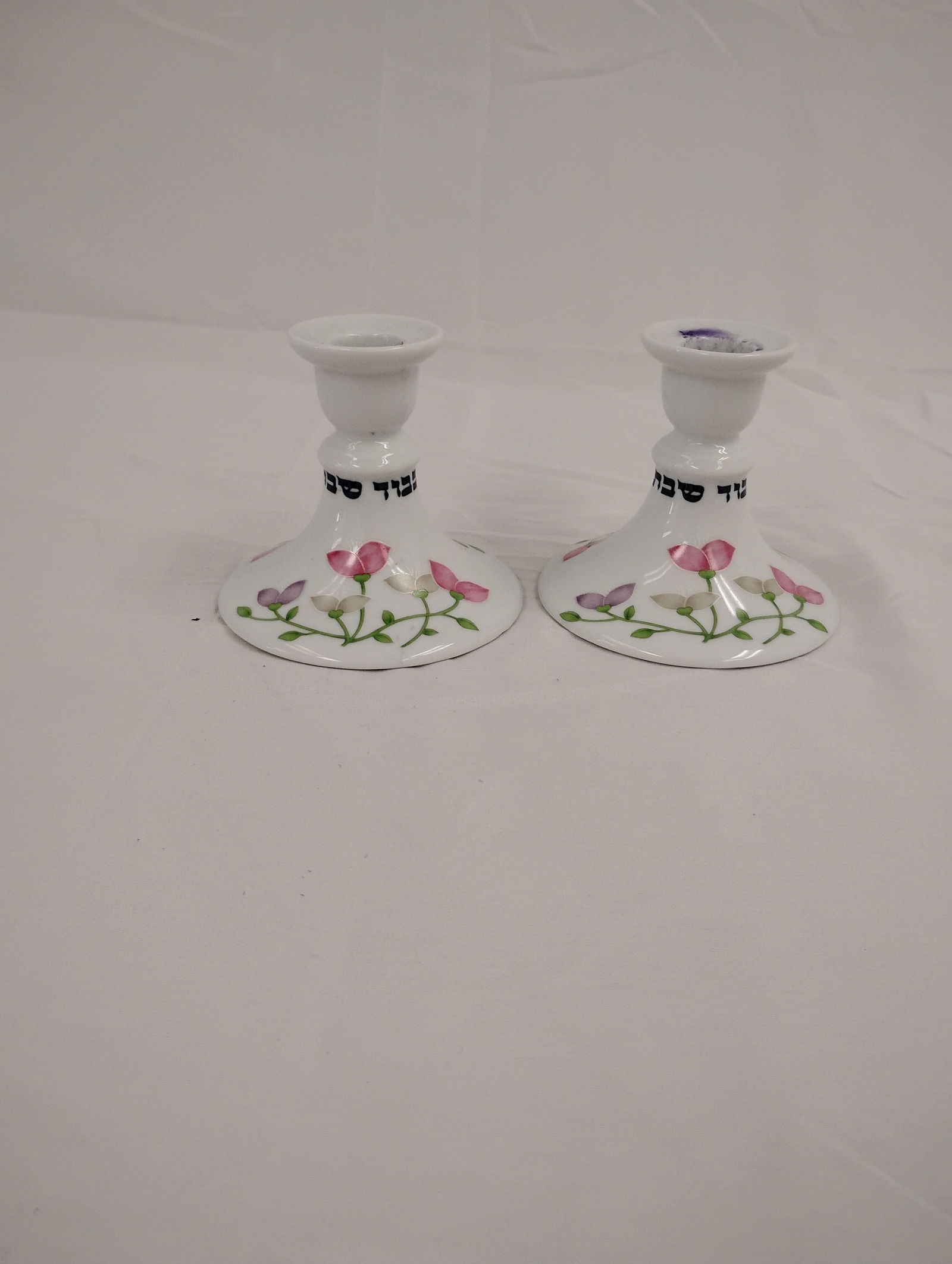Porcelin Hebrew Candle Holders (Set of 2): 2 Porcelin candle holders with Hebrew writing and flower adornment. Made in "House of Prill"